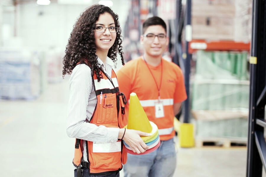 Dos empleados de Ryder colocando conos en un almacén