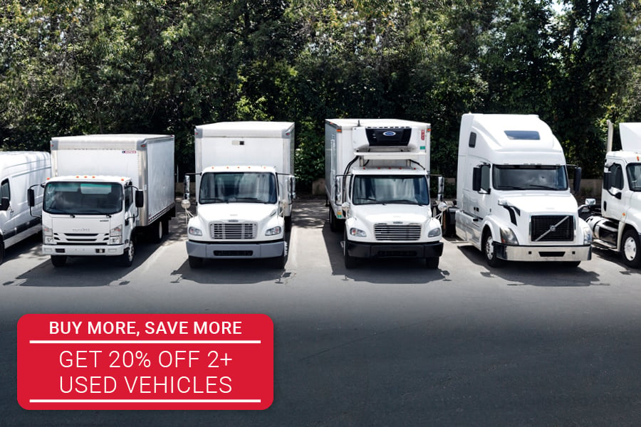 multiple white commercial trucks parked side by side